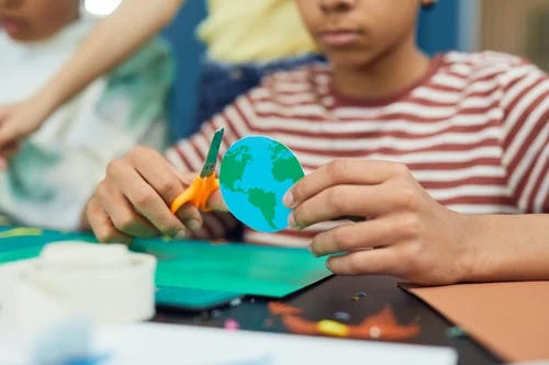 cutting paper craft to make an Earth symbol