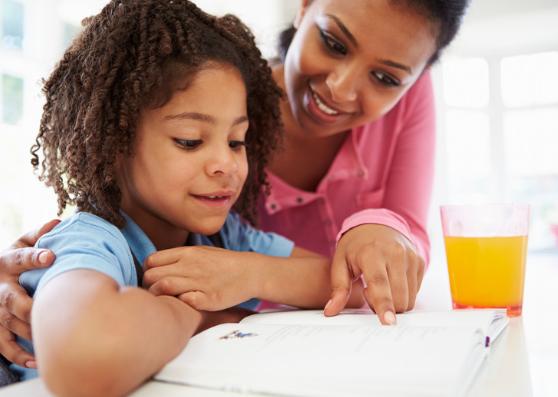 a child reading with her caretaker 